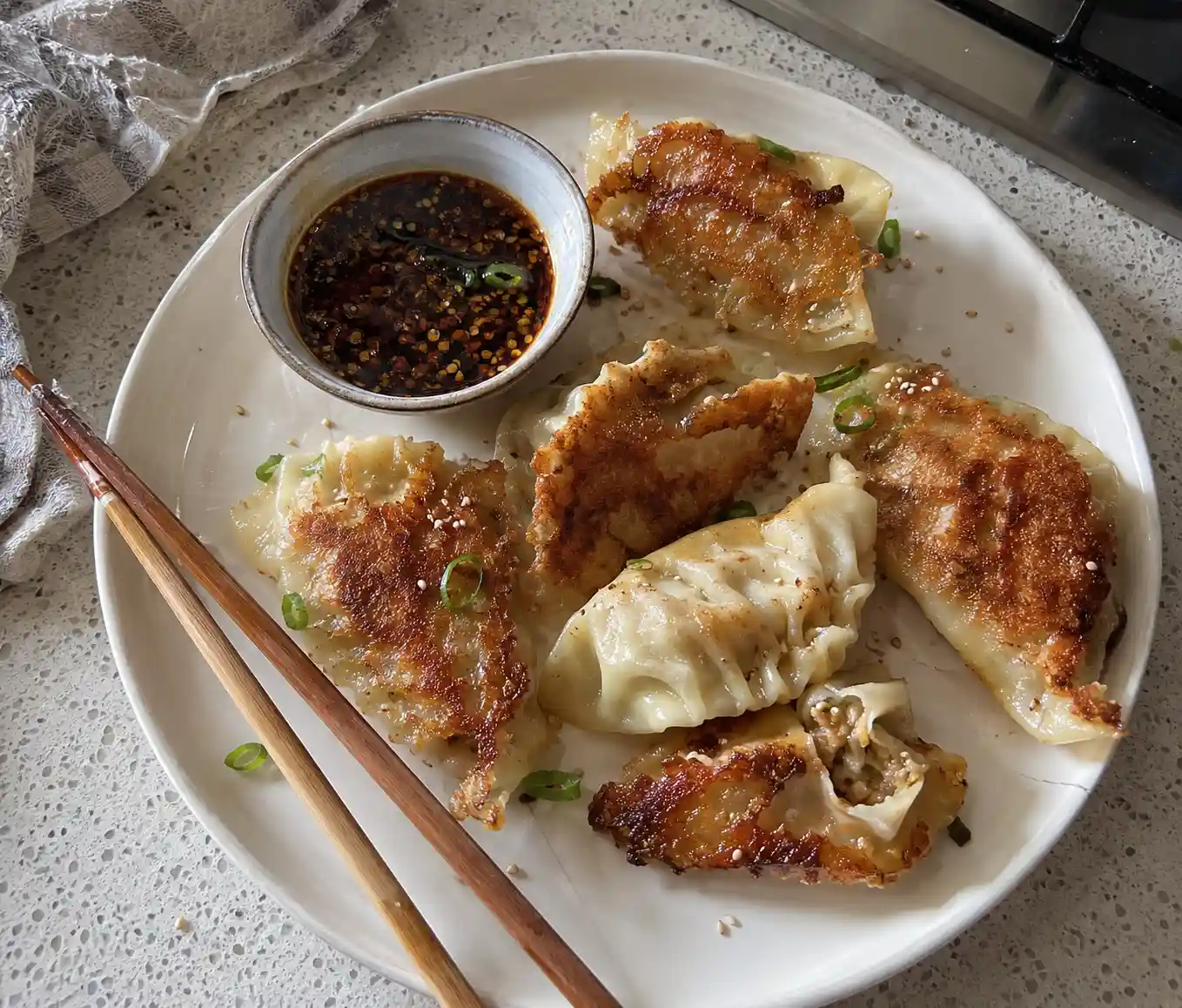 Golden pan seared cabbage dumplings with crispy bottoms served with dipping sauce