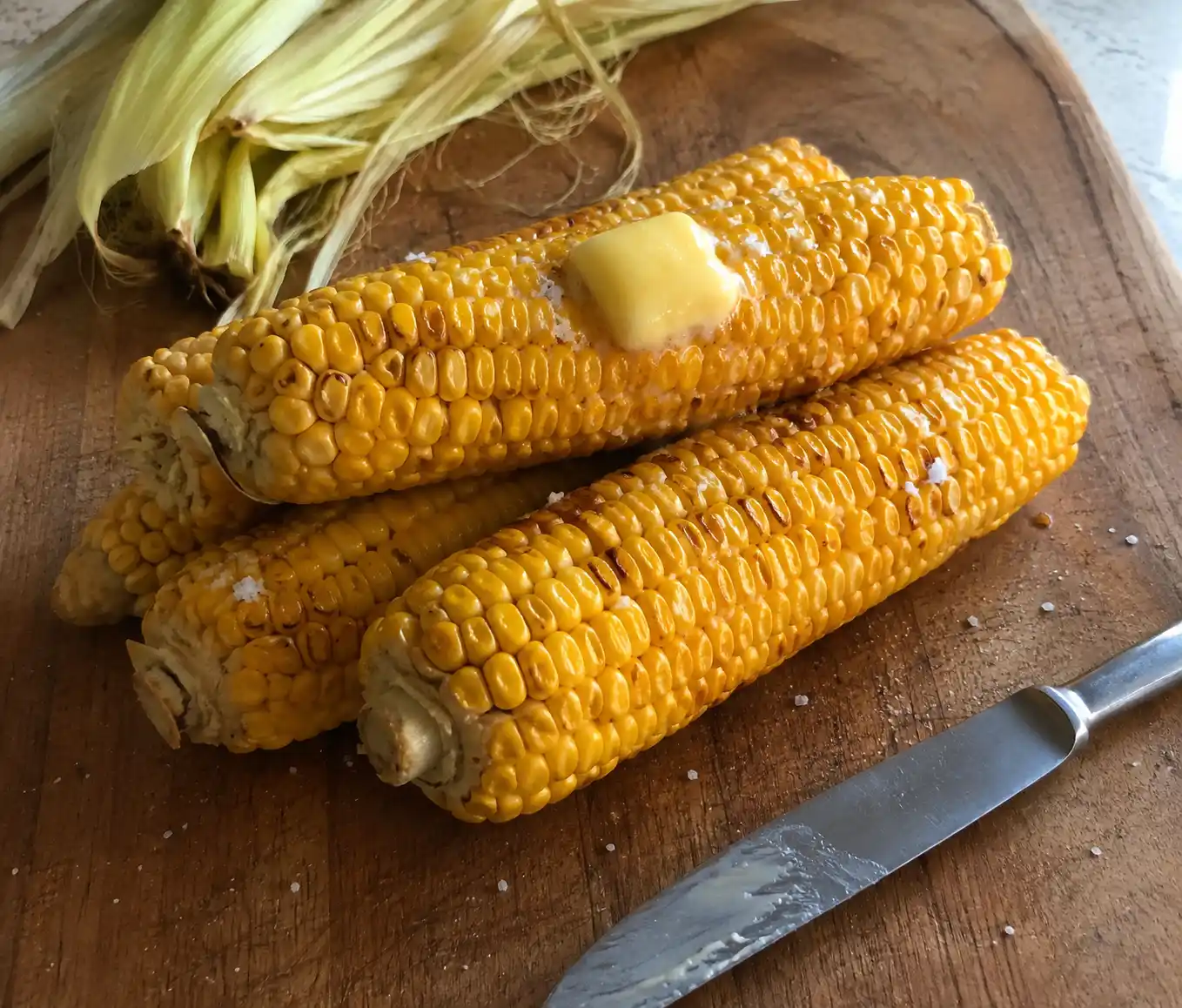 Stack of microwave cooked microwave corn on the cob with husks removed and golden kernels visible